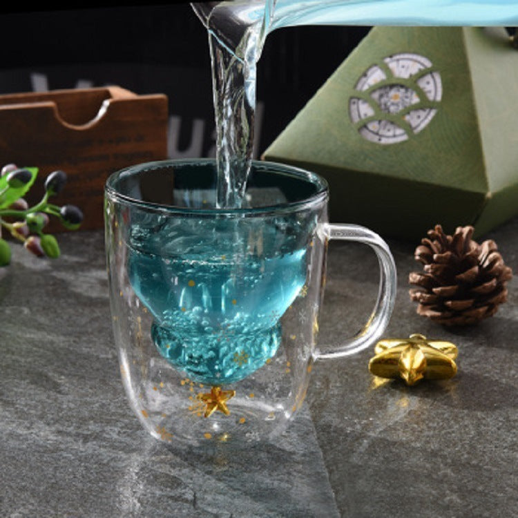 Tasse de noël en verre avec sapin intérieur remplie avec de l'eau